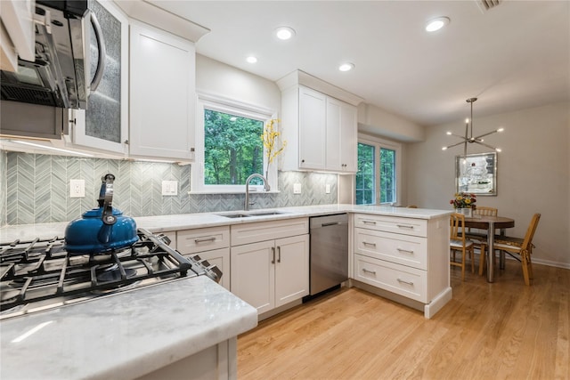 43 Woodglen Dr, New City, NY 10956 - kitchen with appliances with stainless steel finishes, a peninsula, light wood finished floors, white cabinets, and backsplash