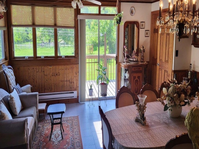 139 Haddock Rd, Monticello, NY 12701 - dining area with a baseboard heating unit, a chandelier, and wooden walls
