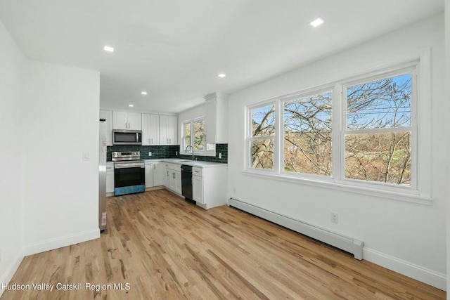 1601 Rte 199, Red Hook, NY 12571 - kitchen with stainless steel appliances, a baseboard radiator, light wood-type flooring, white cabinets, and recessed lighting