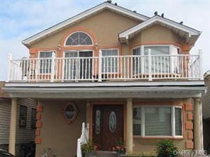 84 Nebraska St, Long Beach, NY 11561 - view of front facade with a balcony and stucco siding