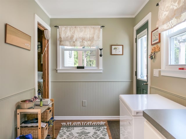 7 Clover Ln, Brookhaven, NY 11719 - laundry area with dark wood finished floors, wainscoting, and crown molding
