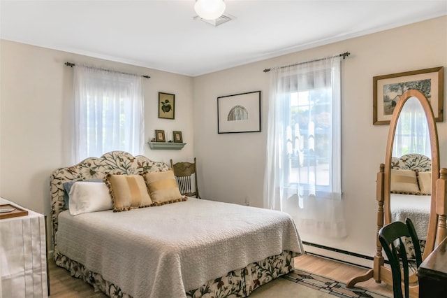 7 Clover Ln, Brookhaven, NY 11719 - bedroom featuring a baseboard radiator and light wood finished floors