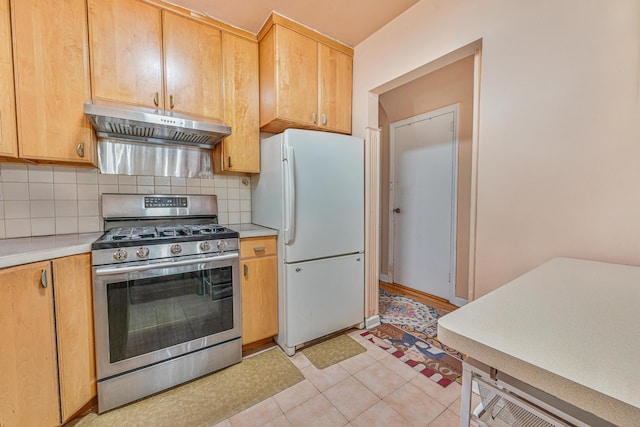 118 Edmund, Lynbrook, NY 11563 - kitchen featuring stainless steel gas range, freestanding refrigerator, extractor fan, light countertops, and decorative backsplash