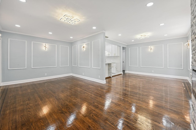 73 Broadway, Valley Stream, NY 11580 - empty room featuring a stone fireplace, crown molding, dark wood-style flooring, recessed lighting, and a decorative wall