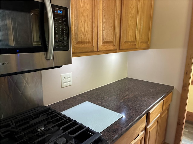 69 Finkle Rd, Summitville, NY 12790 - kitchen with stainless steel microwave, cooktop, brown cabinets, and dark stone counters