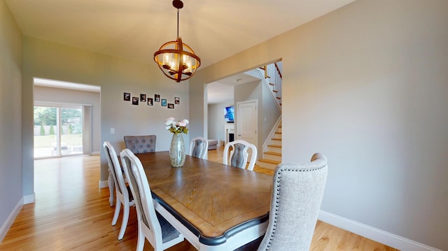9 Shaw Ln, East Moriches, NY 11940 - dining area with light wood-style floors, stairway, and a chandelier