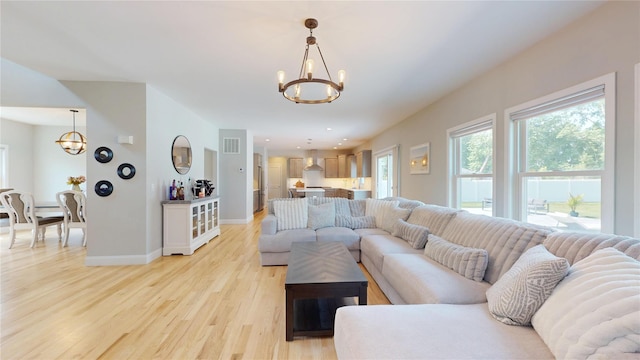 9 Shaw Ln, East Moriches, NY 11940 - living room featuring a chandelier and light wood-type flooring