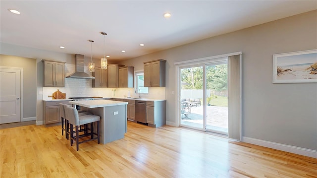 9 Shaw Ln, East Moriches, NY 11940 - kitchen with wall chimney range hood, stainless steel dishwasher, a kitchen island, a breakfast bar area, and light countertops