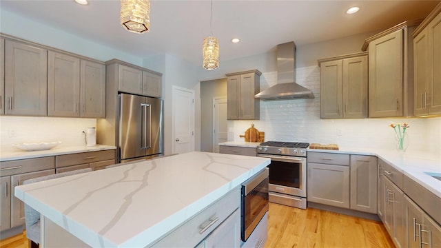 9 Shaw Ln, East Moriches, NY 11940 - kitchen featuring stainless steel appliances, wall chimney range hood, backsplash, light stone countertops, and recessed lighting