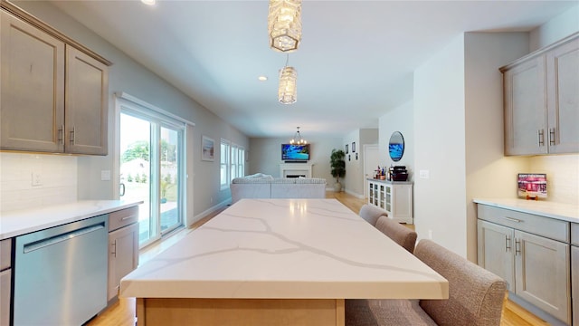 9 Shaw Ln, East Moriches, NY 11940 - kitchen featuring dishwasher, open floor plan, decorative backsplash, decorative light fixtures, and a center island