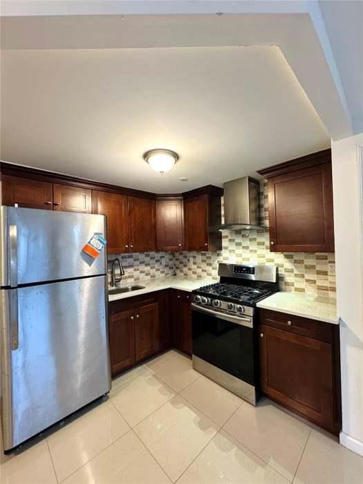 7166 Parsons Blvd Unit 6E, Fresh Meadows, NY 11365 - kitchen with stainless steel appliances, wall chimney range hood, light countertops, tasteful backsplash, and light tile patterned floors