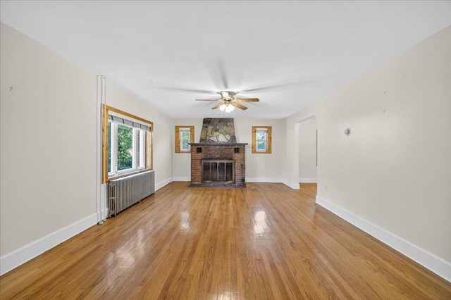 1095 State Route 94, New Windsor, NY 12553 - unfurnished living room with radiator, light wood finished floors, a ceiling fan, and a fireplace