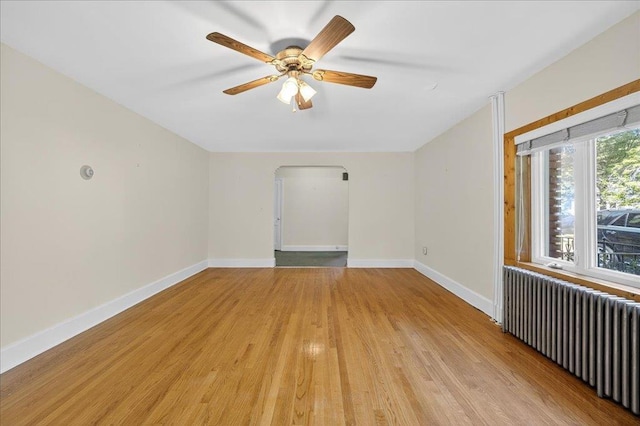 1095 State Route 94, New Windsor, NY 12553 - spare room featuring radiator, light wood finished floors, ceiling fan, and arched walkways