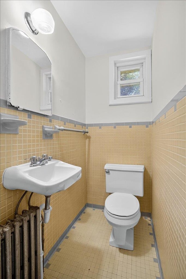 1095 State Route 94, New Windsor, NY 12553 - half bathroom featuring radiator heating unit, tile walls, wainscoting, and tile patterned flooring
