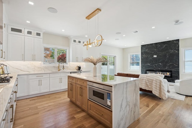 11 Vernon St, Plainview, NY 11803 - kitchen featuring appliances with stainless steel finishes, healthy amount of natural light, light stone countertops, light wood-type flooring, and recessed lighting