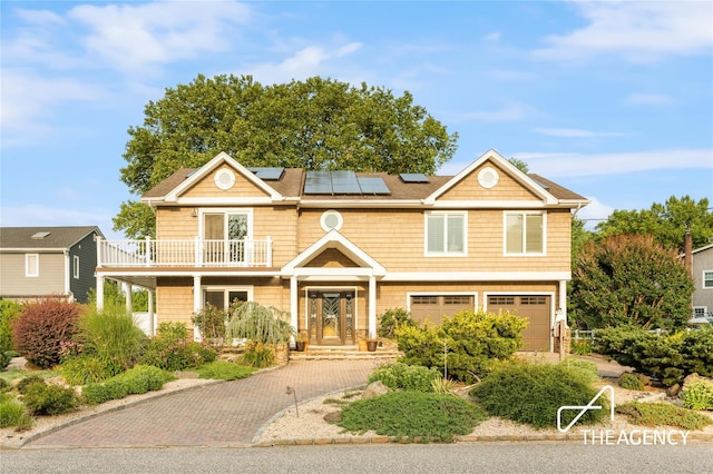 50 Ships Point Ln, Oyster Bay, NY 11771 - view of front of property featuring a balcony, roof mounted solar panels, a garage, and decorative driveway
