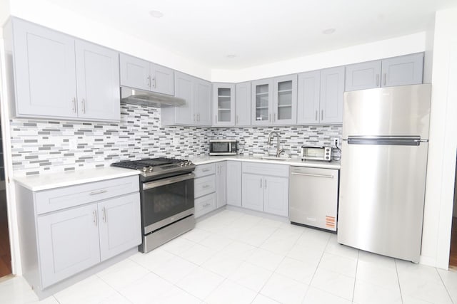 148 Spruce St, Lindenhurst, NY 11757 - kitchen with appliances with stainless steel finishes, under cabinet range hood, gray cabinets, and light countertops