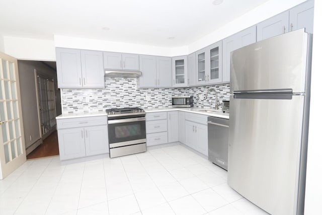 148 Spruce St, Lindenhurst, NY 11757 - kitchen with appliances with stainless steel finishes, gray cabinets, light countertops, glass insert cabinets, and backsplash