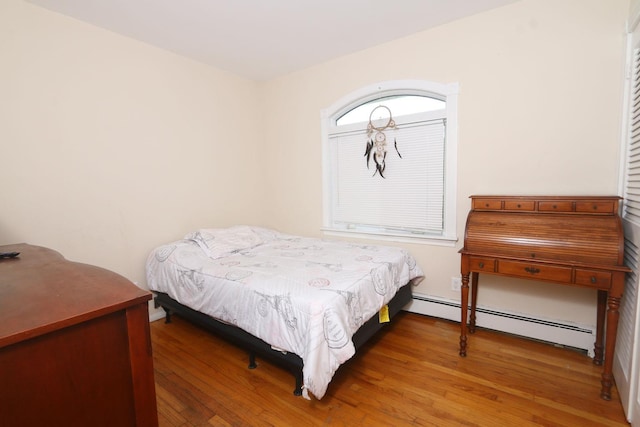 148 Spruce St, Lindenhurst, NY 11757 - bedroom featuring baseboard heating and wood finished floors