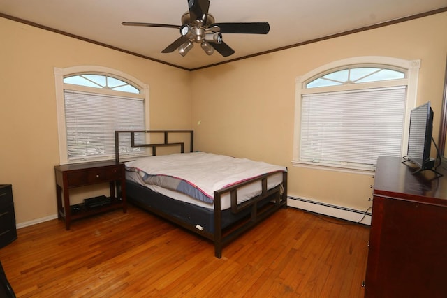 148 Spruce St, Lindenhurst, NY 11757 - bedroom featuring a baseboard heating unit, crown molding, wood-type flooring, multiple windows, and a ceiling fan