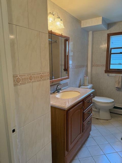 216 Hill Ave, Elmont, NY 11003 - bathroom with tile walls, vanity, tile patterned floors, and backsplash