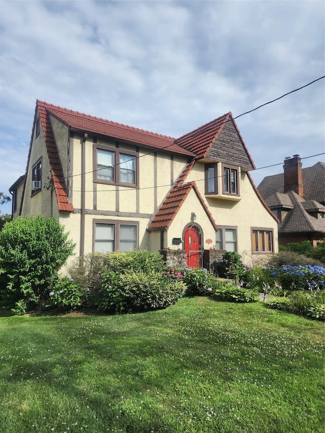 118 Carver Ter, Yonkers, NY 10710 - tudor-style house with stucco siding, a front lawn, and a tile roof