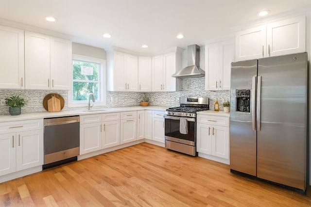 176 Hillsboro Ave, Elmont, NY 11003 - kitchen with appliances with stainless steel finishes, wall chimney range hood, light countertops, white cabinets, and recessed lighting