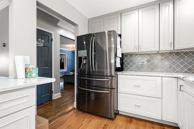 3 Grant Ave, Albertson, NY 11507 - kitchen featuring refrigerator with ice dispenser, decorative backsplash, light wood-type flooring, and light stone counters