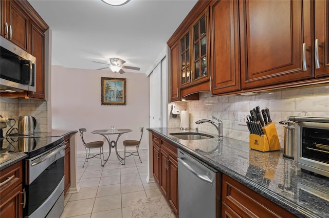 100 High Point Dr Unit 310, Hartsdale, NY 10530 - kitchen featuring stainless steel appliances, dark stone countertops, decorative backsplash, ceiling fan, and light tile patterned floors