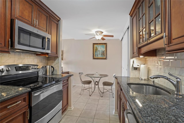 100 High Point Dr Unit 310, Hartsdale, NY 10530 - kitchen with appliances with stainless steel finishes, tasteful backsplash, ceiling fan, light tile patterned flooring, and dark stone countertops
