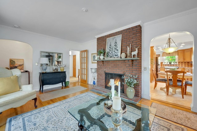 86 Briary Rd, Dobbs Ferry, NY 10522 - living area featuring arched walkways, crown molding, light wood-type flooring, and a brick fireplace