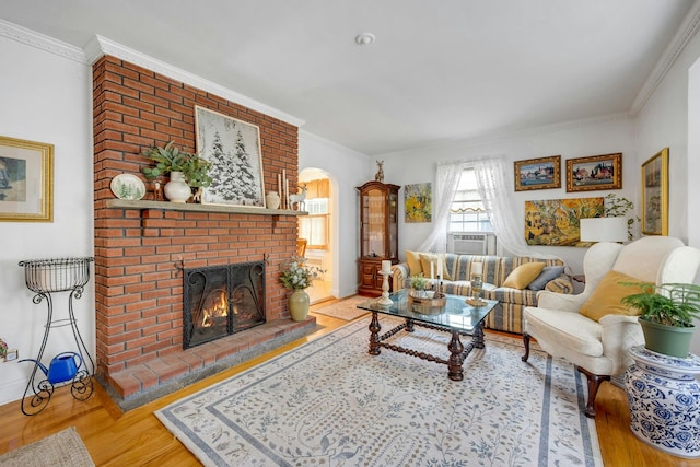 86 Briary Rd, Dobbs Ferry, NY 10522 - living room with wood finished floors, a brick fireplace, crown molding, arched walkways, and cooling unit
