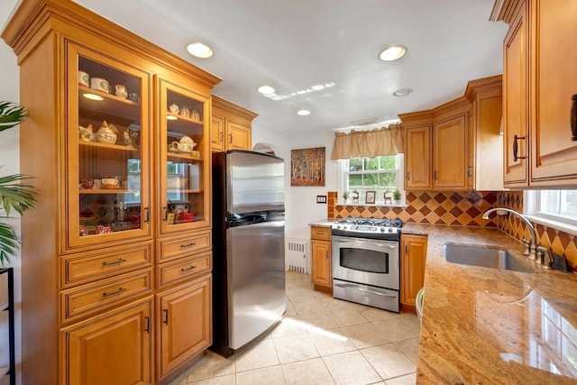86 Briary Rd, Dobbs Ferry, NY 10522 - kitchen with stainless steel appliances, radiator heating unit, backsplash, light stone counters, and light tile patterned floors