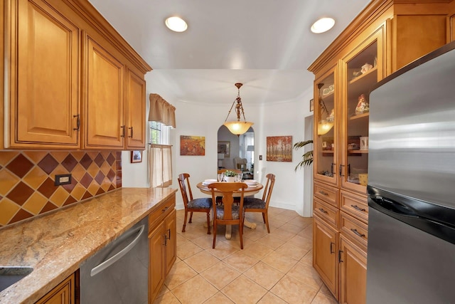 86 Briary Rd, Dobbs Ferry, NY 10522 - kitchen with appliances with stainless steel finishes, tasteful backsplash, light tile patterned flooring, brown cabinetry, and light stone countertops