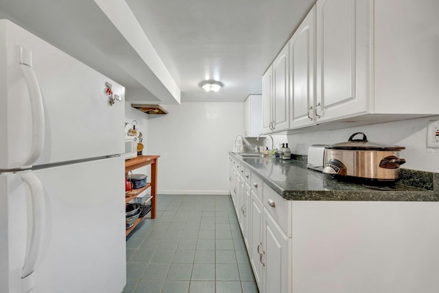 86 Briary Rd, Dobbs Ferry, NY 10522 - kitchen with freestanding refrigerator, white cabinets, and dark countertops