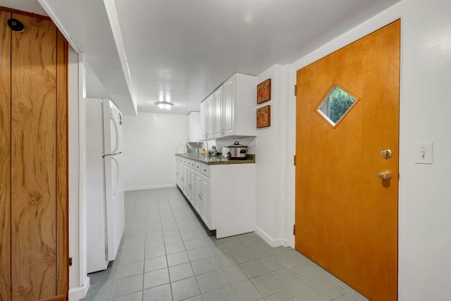 86 Briary Rd, Dobbs Ferry, NY 10522 - kitchen with freestanding refrigerator, white cabinets, light tile patterned flooring, and dark countertops