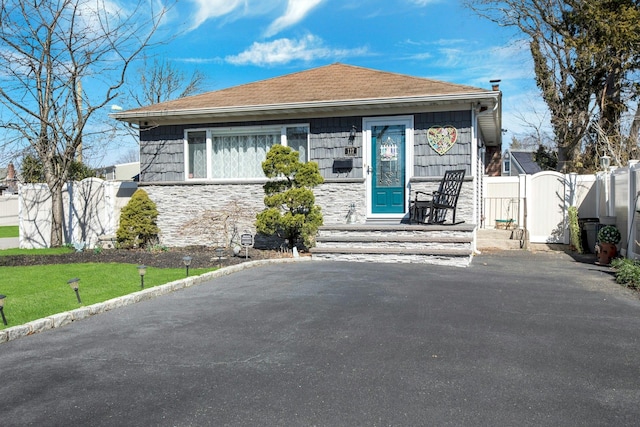 117 E Madison St, East Islip, NY 11730 - bungalow featuring stone siding, a gate, and roof with shingles