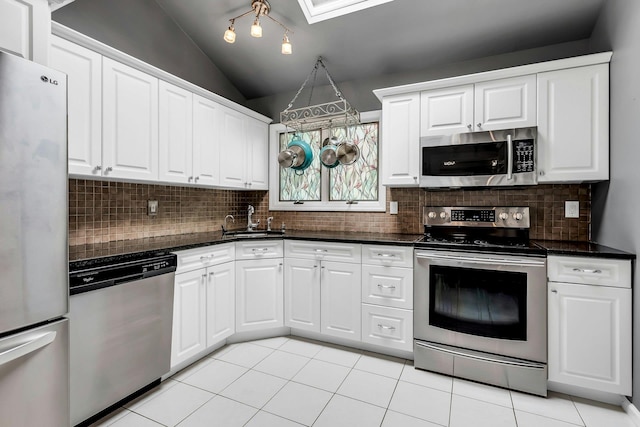 117 E Madison St, East Islip, NY 11730 - kitchen with stainless steel appliances, dark countertops, lofted ceiling, backsplash, and light tile patterned floors