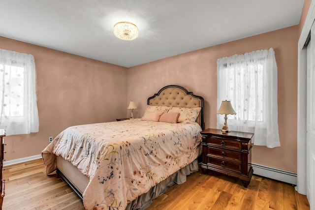 117 E Madison St, East Islip, NY 11730 - bedroom with baseboard heating and wood finished floors
