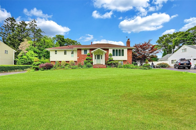 18 Pashen Pl, Dix Hills, NY 11746 - bi-level home with brick siding, a chimney, and a front lawn