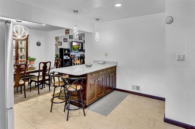 18 Pashen Pl, Dix Hills, NY 11746 - kitchen with a peninsula, freestanding refrigerator, light countertops, a chandelier, and decorative light fixtures