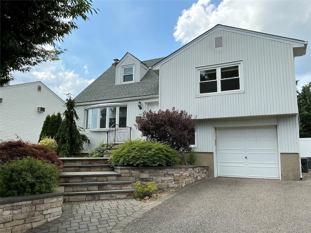 44 Garnet Ln, Plainview, NY 11803 - view of front of home featuring roof with shingles, an attached garage, driveway, and a chimney