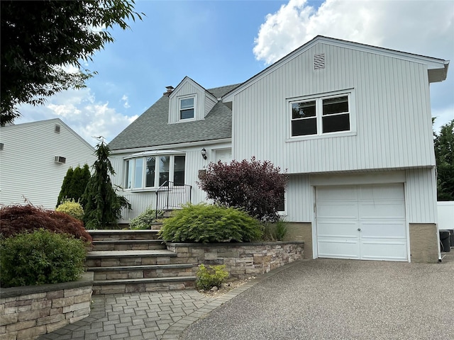 44 Garnet Ln, Plainview, NY 11803 - view of front of home featuring roof with shingles, an attached garage, driveway, and a chimney