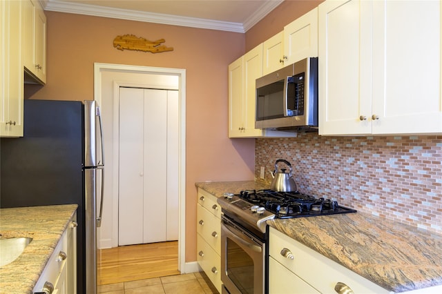 162-41 Powells Cove Blvd Unit 4K, Beechhurst, NY 11357 - kitchen featuring appliances with stainless steel finishes, ornamental molding, tasteful backsplash, and light stone countertops
