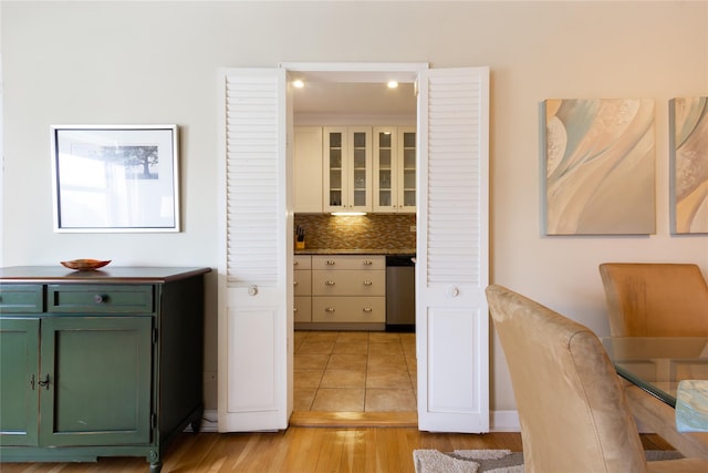 162-41 Powells Cove Blvd Unit 4K, Beechhurst, NY 11357 - kitchen featuring green cabinetry, tasteful backsplash, light wood-type flooring, stainless steel dishwasher, and glass insert cabinets