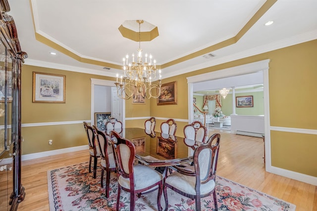 3 Kohlsaat Ct, Smithtown, NY 11787 - dining room featuring a chandelier, a raised ceiling, light wood-style floors, crown molding, and a baseboard radiator