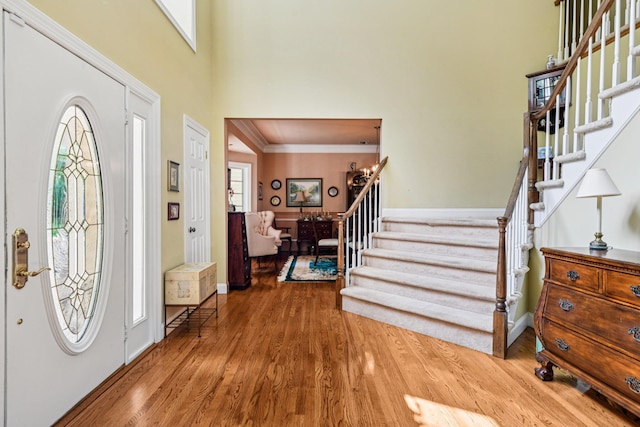 10 Bryan Meadow Path, Northport, NY 11768 - entrance foyer with stairway, wood finished floors, a towering ceiling, and ornamental molding