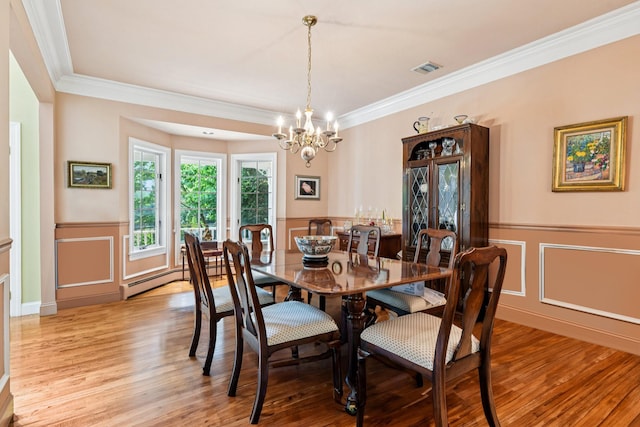 10 Bryan Meadow Path, Northport, NY 11768 - dining room featuring a decorative wall, light wood-type flooring, a chandelier, ornamental molding, and a wainscoted wall