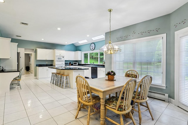 10 Bryan Meadow Path, Northport, NY 11768 - dining room featuring a chandelier, a skylight, light tile patterned floors, baseboard heating, and vaulted ceiling