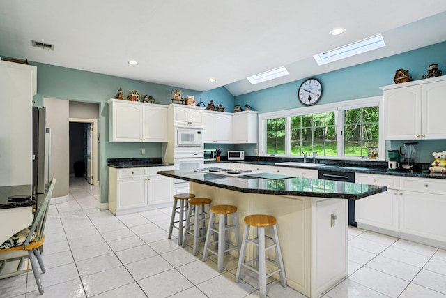 10 Bryan Meadow Path, Northport, NY 11768 - kitchen featuring white appliances, a skylight, light tile patterned flooring, a breakfast bar area, and vaulted ceiling